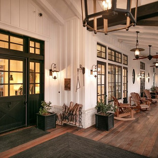 Idee per un grande portico country davanti casa con pedane e un tetto a sbalzo