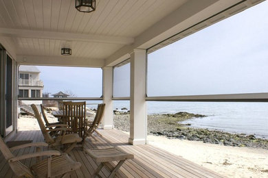 Mid-sized beach style screened-in back porch photo in New York with a roof extension and decking
