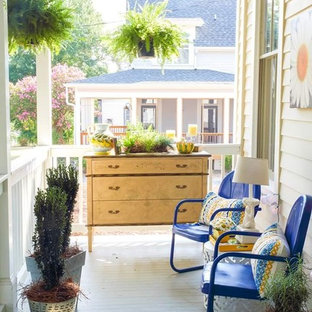 Idee per un piccolo portico eclettico davanti casa con un giardino in vaso, pedane e un tetto a sbalzo