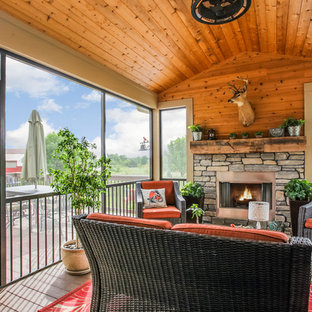 Esempio di un portico stile americano dietro casa con un caminetto, pedane e un tetto a sbalzo