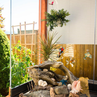 Esempio di un portico tropicale dietro casa con pedane e una pergola