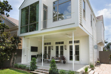 Immagine di un portico minimal di medie dimensioni e dietro casa con un focolare, pavimentazioni in mattoni e un tetto a sbalzo