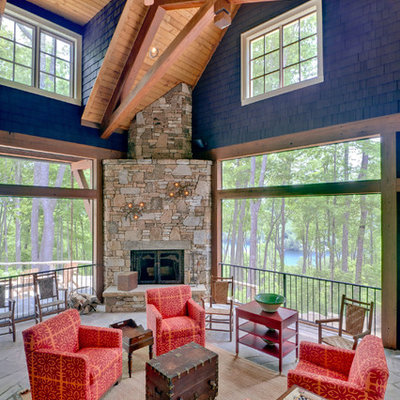 Inspiration for a large rustic stone side porch remodel in Other with a fire pit and a roof extension