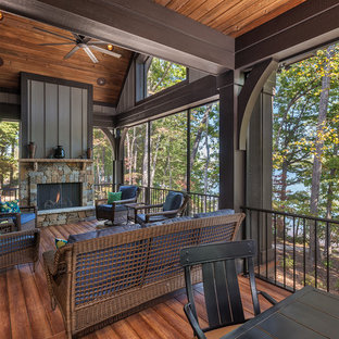 Idee per un grande portico stile americano dietro casa con un portico chiuso, pedane e un tetto a sbalzo