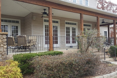 This is an example of a large craftsman concrete front porch design in Charlotte with a roof extension.