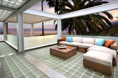 This is an example of a large modern back veranda in Orange County with a roof extension.