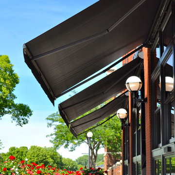 Charmant Hotel - Three side by side black framed folding lateral arm awnings