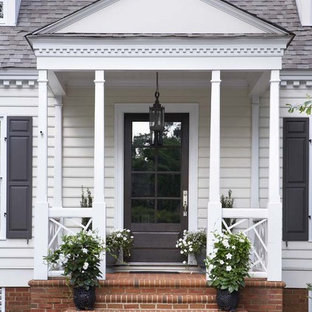 Idee per un piccolo portico chic davanti casa con un giardino in vaso, pavimentazioni in mattoni e un tetto a sbalzo