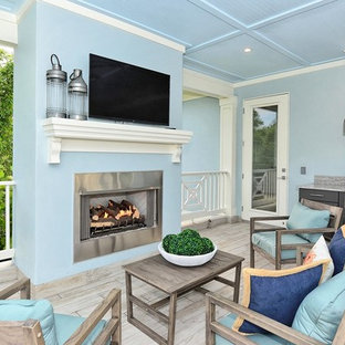 Ispirazione per un grande portico american style con un caminetto, piastrelle e un tetto a sbalzo