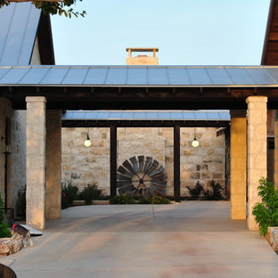 Ispirazione per un grande portico country davanti casa con lastre di cemento e un tetto a sbalzo