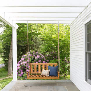 Foto di un portico country davanti casa con pavimentazioni in cemento e una pergola