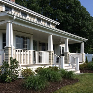 Immagine di un grande portico country davanti casa con pedane e un tetto a sbalzo