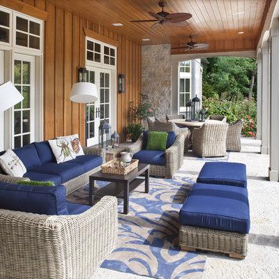 This is an example of a mid-sized traditional back porch design in Milwaukee with a roof extension.