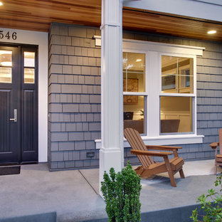 Esempio di un portico stile americano davanti casa con un tetto a sbalzo e lastre di cemento