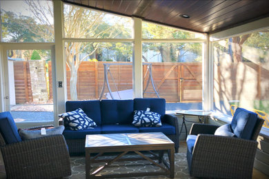 This is an example of a mid-sized craftsman stone screened-in back porch design in Austin with a roof extension.