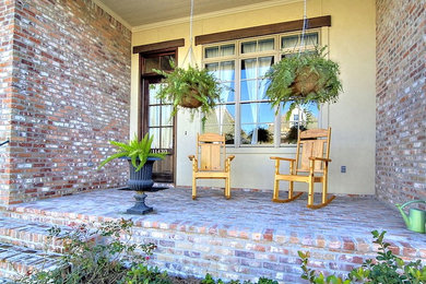 Inspiration for a mid-sized timeless brick front porch remodel in New Orleans