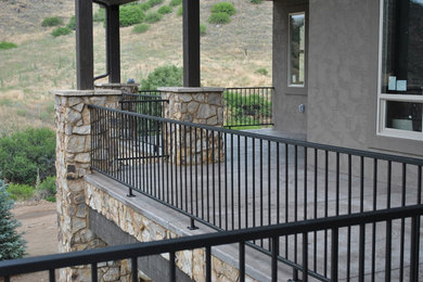 Inspiration for a large rustic concrete back porch remodel in Denver with a roof extension