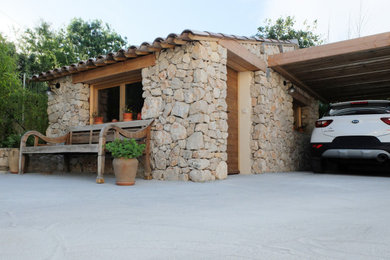 Cette image montre un petit porche d'entrée de maison arrière méditerranéen avec des pavés en pierre naturelle et une pergola.