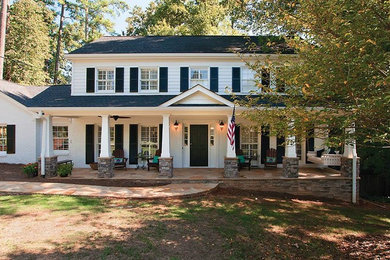Large elegant stone front porch photo in Atlanta with a roof extension