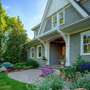 Immagine di un grande portico stile americano davanti casa con pavimentazioni in mattoni