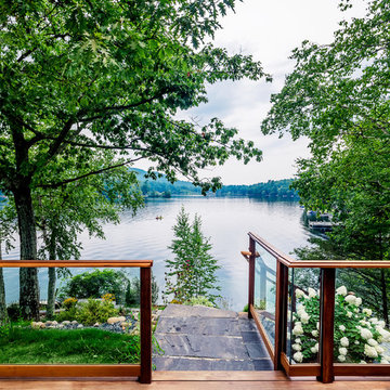 Custom glass railings surround the lakeside deck with minimal obstruction to the
