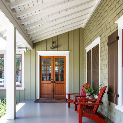 Beach style concrete front porch photo in Jacksonville with a roof extension