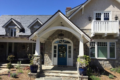 Mid-sized elegant stone front porch photo in San Diego with a roof extension