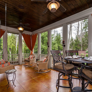 Immagine di un grande portico american style dietro casa con un portico chiuso, un tetto a sbalzo e piastrelle