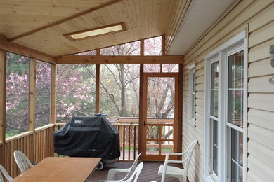 Inspiration for a mid-sized timeless screened-in back porch remodel in DC Metro with a roof extension