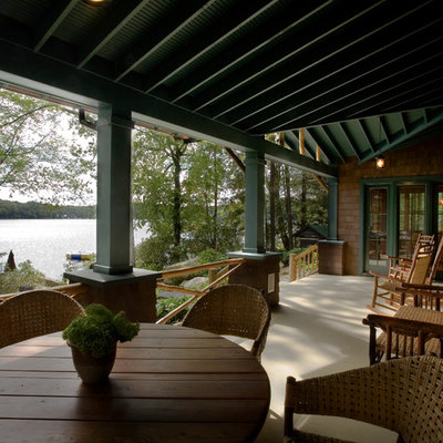 Large mountain style front porch photo in New York with a roof extension