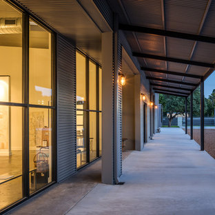 Idee per un grande patio o portico industriale davanti casa con lastre di cemento e un tetto a sbalzo