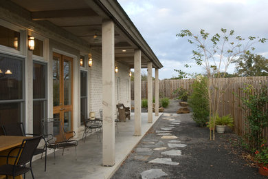 Ejemplo de terraza tradicional renovada pequeña en patio lateral y anexo de casas con losas de hormigón