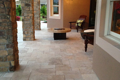 This is an example of a large traditional porch design in Miami with a fire pit.