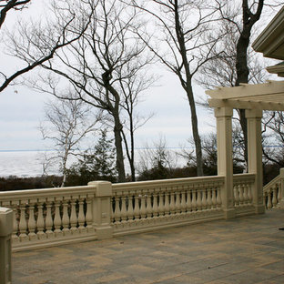 Immagine di un ampio portico eclettico dietro casa con pavimentazioni in cemento e una pergola