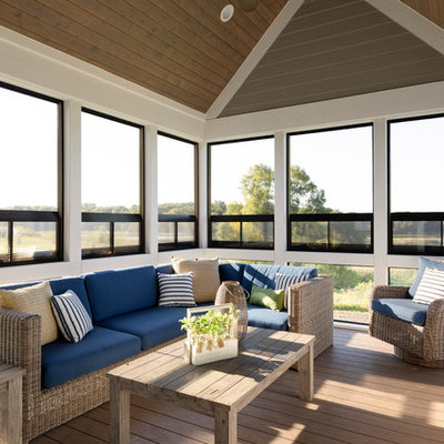 Beach style screened-in back porch idea in Minneapolis with a roof extension and decking
