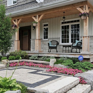 Idee per un portico american style di medie dimensioni e davanti casa con pavimentazioni in pietra naturale e un tetto a sbalzo