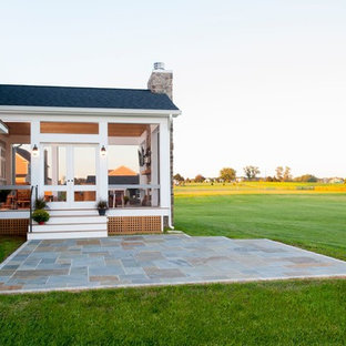 Ispirazione per un grande portico stile rurale dietro casa con un portico chiuso, pedane e un tetto a sbalzo