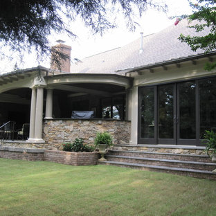 Immagine di un grande portico rustico dietro casa con piastrelle e un tetto a sbalzo
