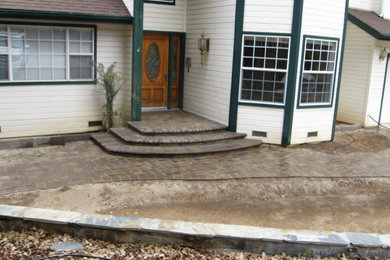Mid-sized mountain style concrete paver front porch idea in Other