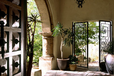 Design ideas for a large mediterranean front veranda in Phoenix with a roof extension and brick paving.