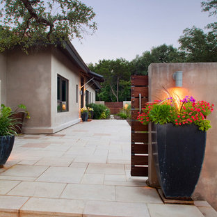 Immagine di un grande portico industriale davanti casa con un giardino in vaso e pavimentazioni in cemento