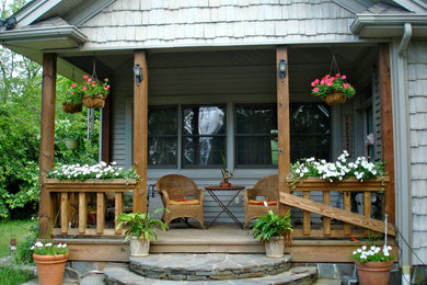 This is an example of a traditional front porch design in New York with decking and a roof extension.