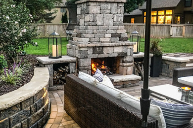 Large minimalist backyard concrete paver patio photo in Kansas City with a fireplace