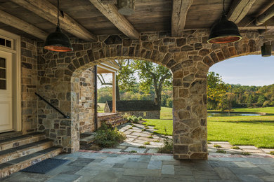 Photo of a farmhouse side veranda in Philadelphia with natural stone paving and a roof extension.