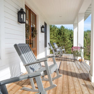 Ispirazione per un grande portico country davanti casa con pedane e un tetto a sbalzo