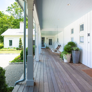 Foto di un portico country davanti casa e di medie dimensioni con pedane e un tetto a sbalzo