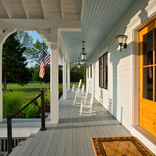 Foto di un grande portico country davanti casa con pedane e un tetto a sbalzo