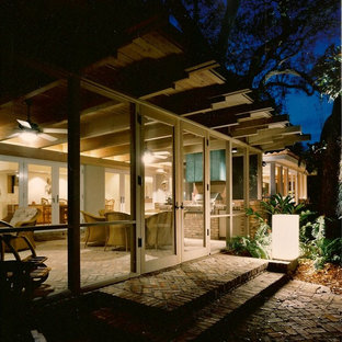 Foto di un portico contemporaneo di medie dimensioni e dietro casa con un portico chiuso, pavimentazioni in mattoni e un tetto a sbalzo