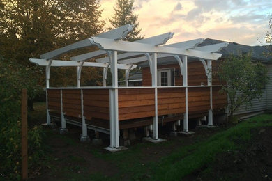 This is an example of a mid-sized traditional back porch design in Portland with a pergola.