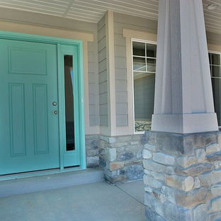 Immagine di un piccolo portico stile americano davanti casa con lastre di cemento e un tetto a sbalzo